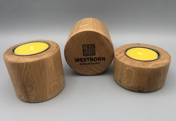 Westborn Woodcraft logo on the bottom of three wooden candle holdens with honey wax tea lights